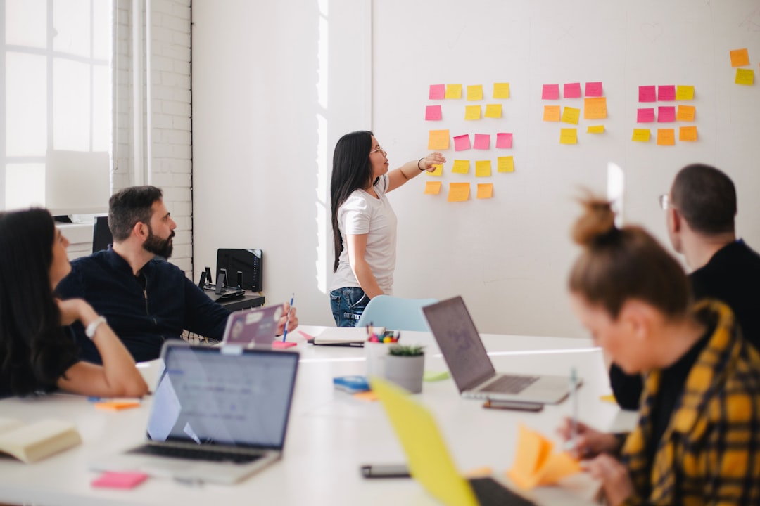 Photo by Jason Goodman woman placing sticky notes on wall